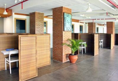Shared workspace area with privacy booths made of woven bamboo panels and brick pillars.