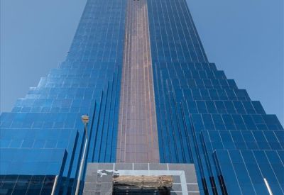 Exterior view of the blue glass facade and entrance of Almoayyed Tower.