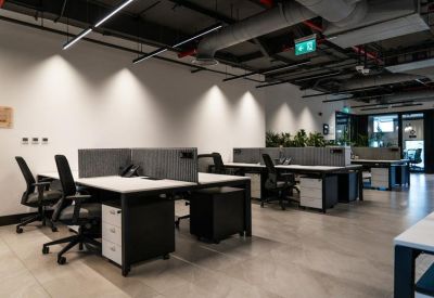 Wide-angle view of a contemporary shared office space with ergonomic seating and track lighting.