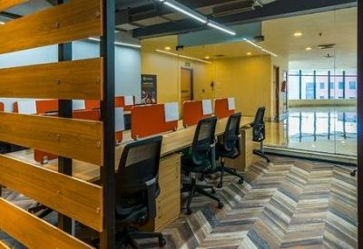 Office workspace with wooden slat partitions and ergonomic mesh chairs.