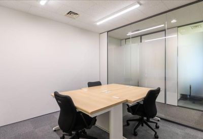 Private internal office with light wood desk and glass partition wall.
