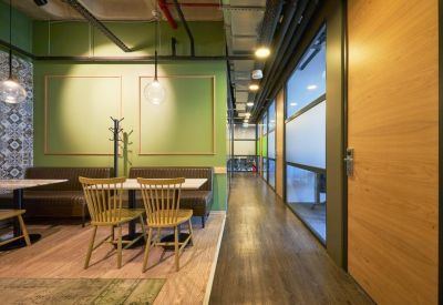 Cafe-style seating area with green feature walls and decorative pendant lights.