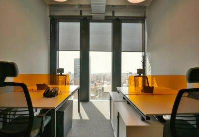 Private office for two with white desks, ergonomic chairs, and orange privacy dividers.
