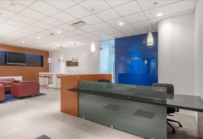 Modern reception area with a sleek glass desk and a blue feature wall.