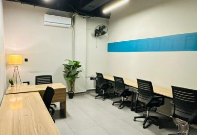 Private office space featuring wooden desks, black chairs, and a minimalist blue wall accent.