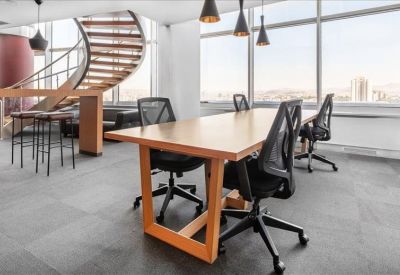 Modern breakout area featuring a wooden table and a striking spiral staircase.