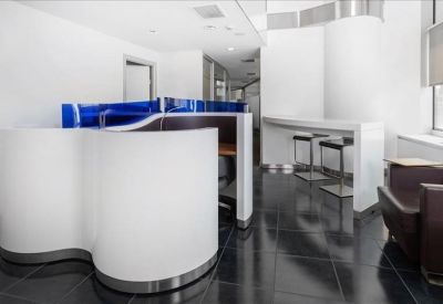 Sleek modern reception area with curved white desks and a vibrant blue glass accent wall.