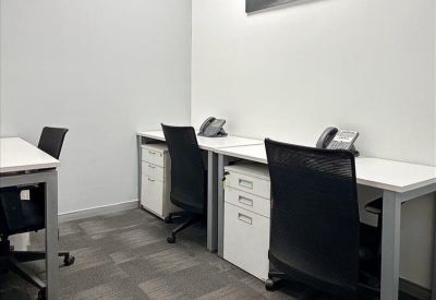Modern coworking space with wooden floors and semi-private booth seating.