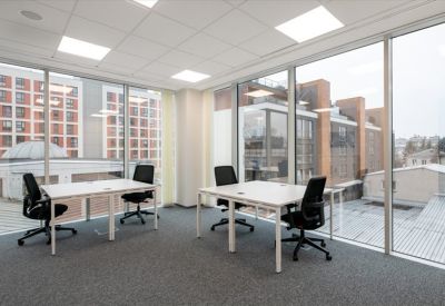Private office suite with two desks and floor-to-ceiling windows overlooking the city.