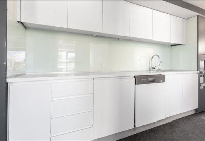 Clean, modern kitchen area with white cabinetry and an integrated dishwasher.