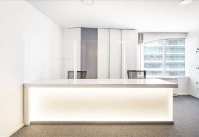 Bright reception desk with integrated LED lighting and a clean white finish.