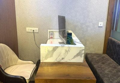 Professional reception desk featuring a marble-patterned front and a comfortable guest bench.