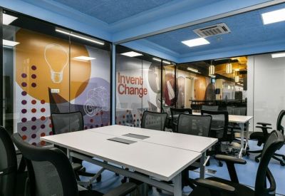 Modern meeting room with glass walls, branded graphics, and ergonomic chairs.