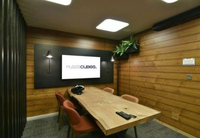 Private office suite with a natural wood live-edge desk and integrated wall monitor.