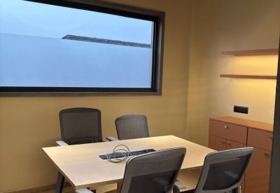 Private four-person meeting room with a large pendant light and wooden cabinetry.