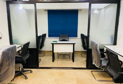 Small private office suite with a central desk seen through a glass partition.