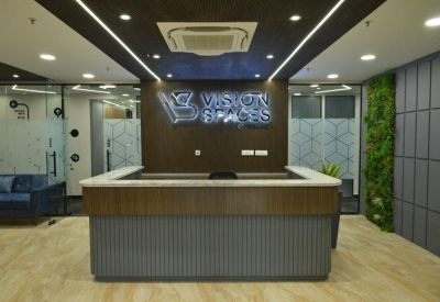 Reception area at BBD Viraj Tower, 4th Floor with wood accents and a green feature wall.