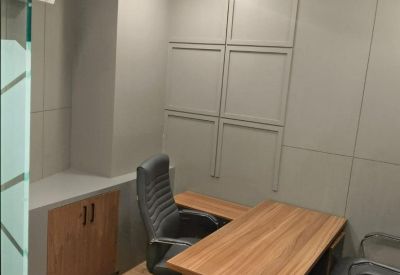 Private office suite featuring a wooden desk and grey textured wall panels.