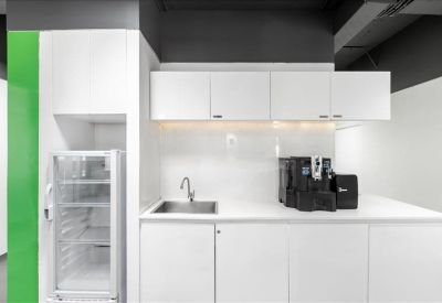 Clean white kitchen area with a built-in coffee station and green wall panel.