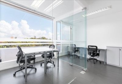 Bright glass-walled office with modern workstations and natural light.