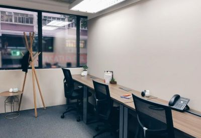 Private office suite with a long wooden desk and three mesh chairs.