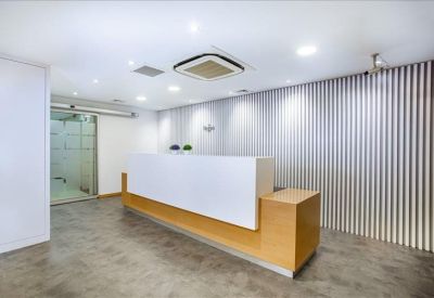 Sleek minimalist reception desk with a wood-slat feature wall.