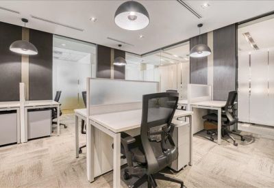 Modern open-plan office with white desks, ergonomic mesh chairs, and stylish dome pendant lighting.