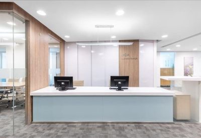 Professional reception desk in light blue and white with wood-paneled accents.