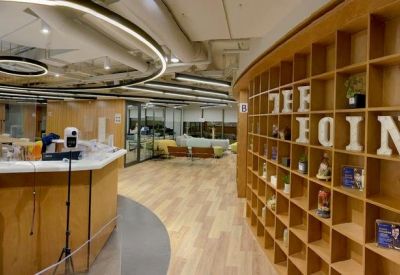 Reception and lounge area at New Mandarin Plaza with wood shelving and curved ceiling lights.