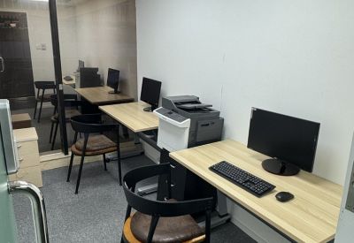 Private office room with three wooden desks, black chairs, and a printer.