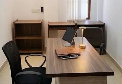 Private office featuring a wooden desk with a tablet, lamp, and ergonomic mesh chair.