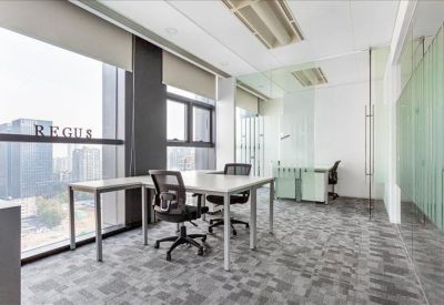 Spacious private office with corner windows and two workstations.