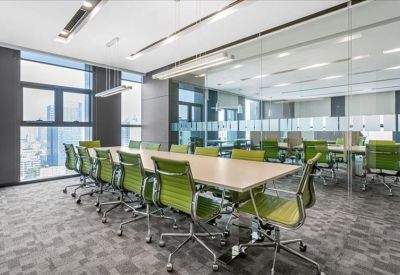 Long boardroom featuring lime green chairs and expansive city views through floor-to-ceiling windows.
