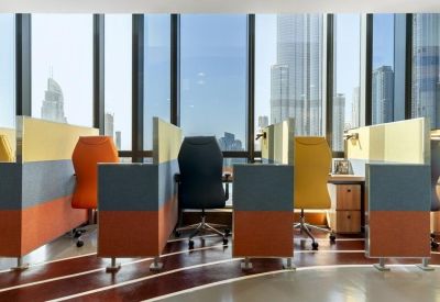 Colorful open-plan workspace with partitioned desks and floor-to-ceiling city views.