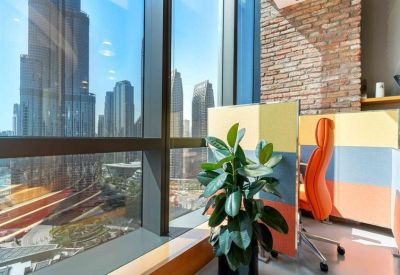 Compact workstation area by a window with a brick feature wall and city views.
