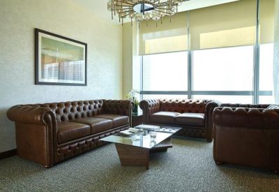 Sophisticated lounge area with brown tufted leather sofas and a glass coffee table.