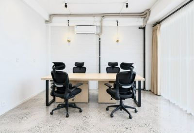 Bright conference room with a light wood table and six ergonomic chairs.