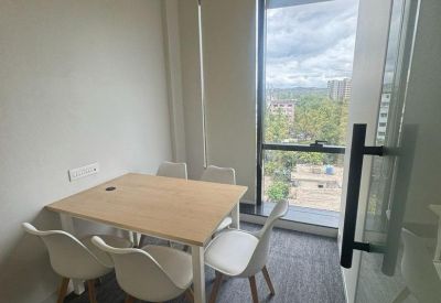 Bright private meeting room featuring a wooden table, four white chairs, and large window with city views.
