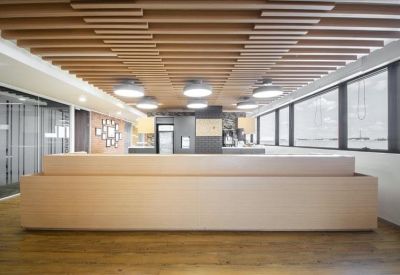 Sleek, minimalist reception desk with a distinctive slatted wood ceiling design.