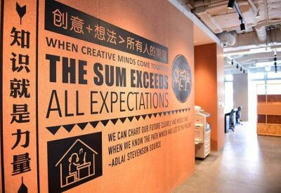 Feature wall with inspirational English and Chinese text and a small office corridor.