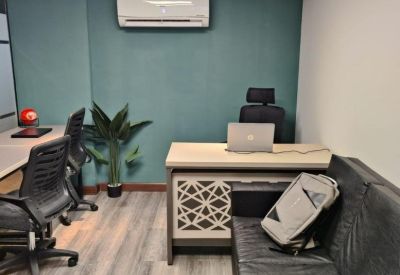 Office interior featuring a black leather sofa and a desk with a geometric pattern.