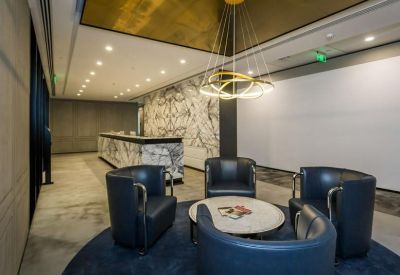 Modern reception lobby with marble front desk and circular gold light fixture.