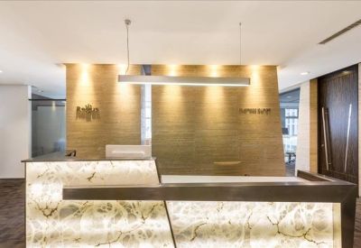 Sleek reception area with a backlit marble desk and warm feature lighting.