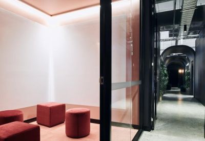 Meeting room with red velvet stools and soft warm lighting.