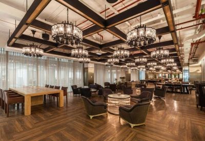 Spacious communal lounge with ornate chandeliers and herringbone wood floors.
