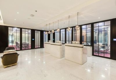 Bright white marble reception area with glass-partitioned meeting rooms.