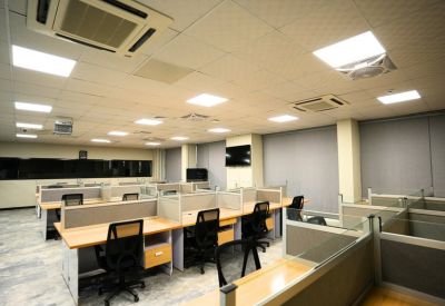 Open office area with white-partitioned desks and black mesh task chairs.