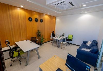 Modern private office with wood-paneled walls, desk, and a comfortable blue sofa.