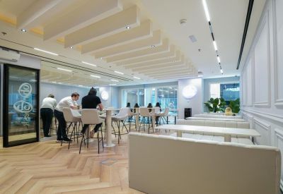 Casual coworking lounge with high-top tables and comfortable white seating.