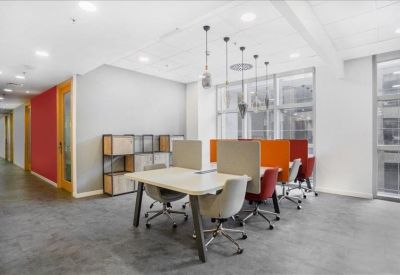 Coworking space with colorful orange dividers and modern task lighting.